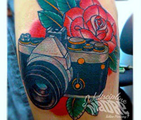 tatuaje en el brazo: una cámara de fotos y una rosa