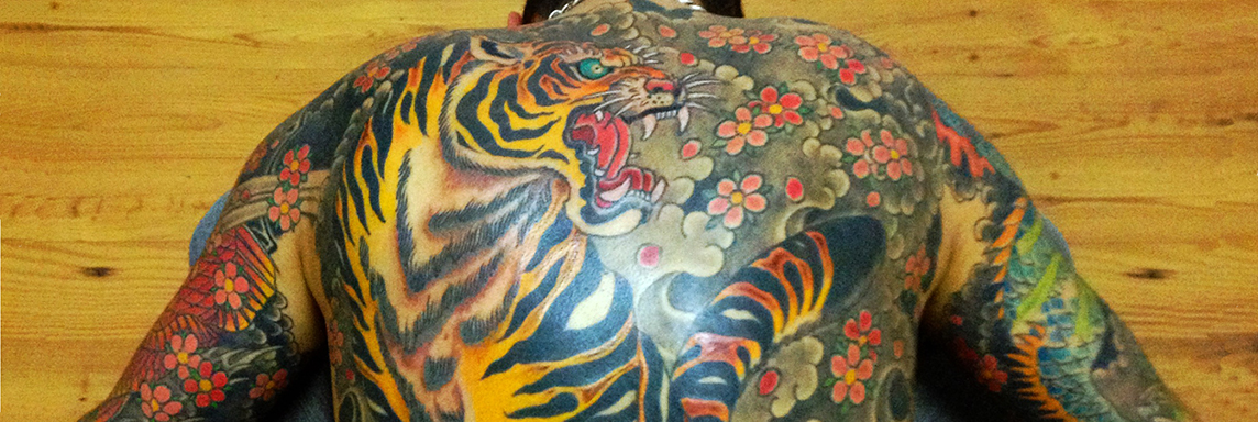 tatuaje a color en toda la espalda: un tigre con flores